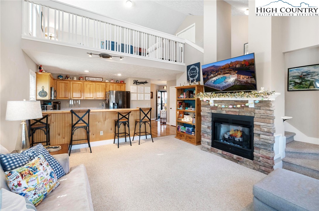 446 Peaceful Haven Drive, Unit 832 Boone, NC 28607 - Photo 5 of 38 a living room with furniture a fireplace and a flat screen tv