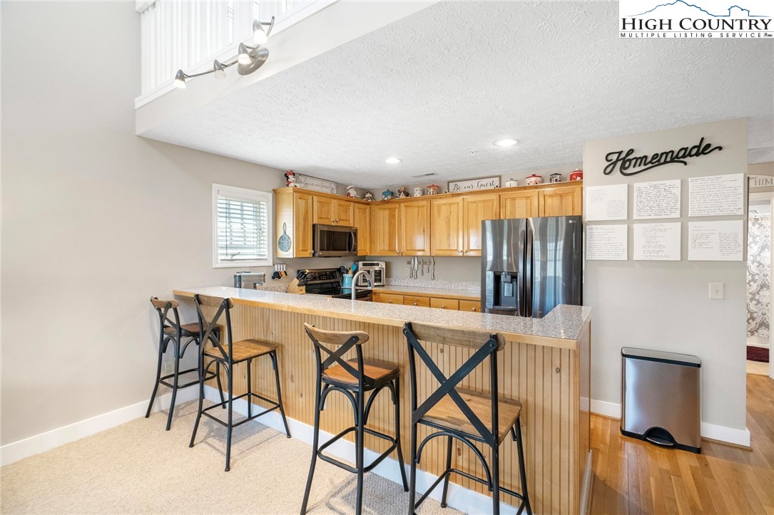 446 Peaceful Haven Drive, Unit 832 Boone, NC 28607 - Photo 7 of 38 a kitchen with stainless steel appliances a table and chairs in it