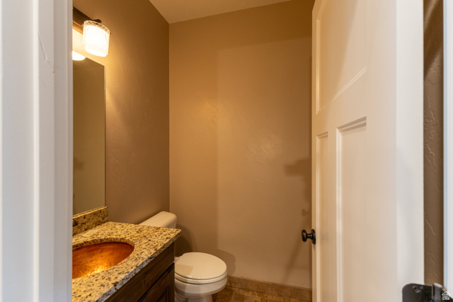 3565 West 1350th Street North Vernal, UT 84078 - Photo 14 of 54 Powder room with a granite countertop vanity, vessel sink, and an overhead vanity light