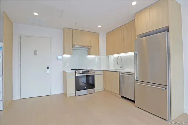 a kitchen with stainless steel appliances granite countertop white refrigerator a stove a sink and a refrigerator