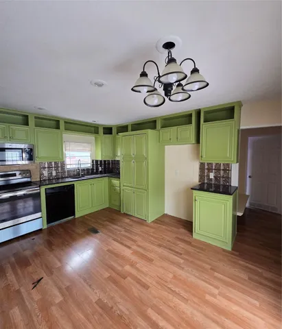 a kitchen with stainless steel appliances kitchen island a refrigerator and a stove top oven