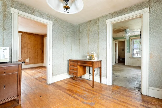 a view of a livingroom with wooden floor and a ceiling fan