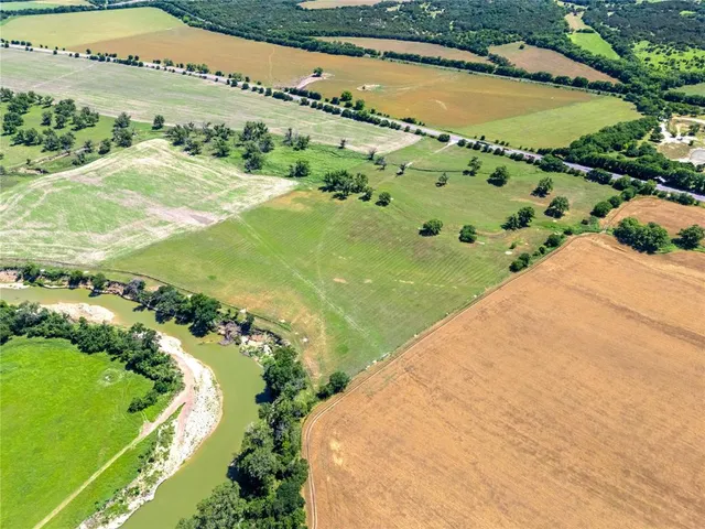 a view of a water pond with green field