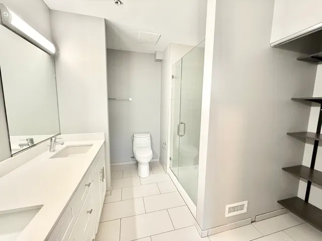 a spacious bathroom with a granite countertop sink a toilet and a shower