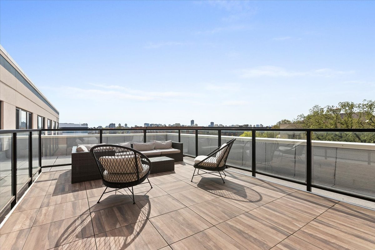 1900 West Lawrence Avenue, Unit 231 Chicago, IL 60640 - Photo 24 of 28 a roof deck with outdoor seating and city view