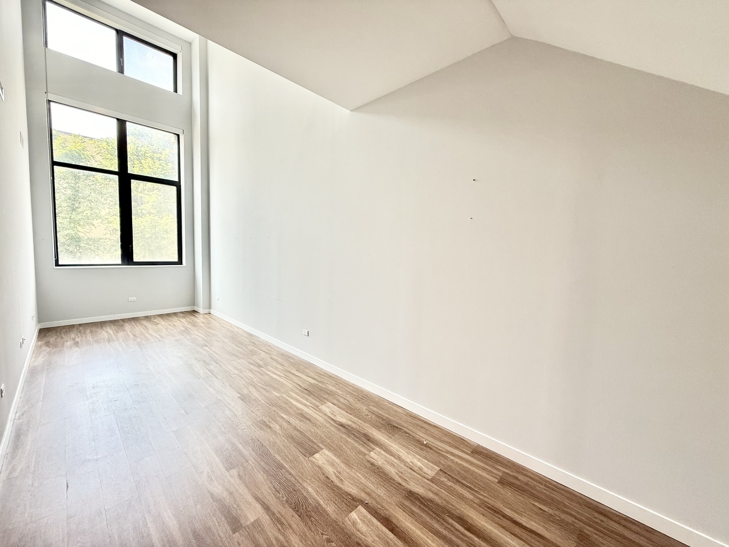 1900 West Lawrence Avenue, Unit 231 Chicago, IL 60640 - Photo 5 of 28 an empty room with wooden floor and windows