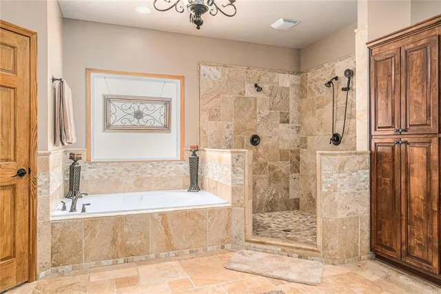 a spacious bedroom with a bed and a chandelier