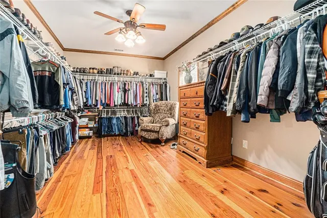 a spacious bedroom with a bed a couch and a flat screen tv