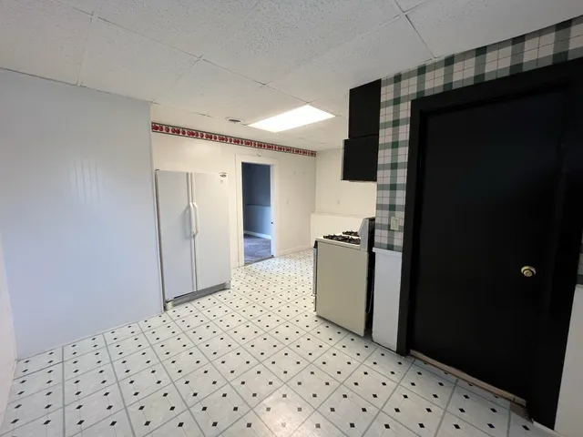 a kitchen with a checkered floor and a refrigerator