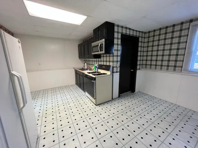a kitchen with granite countertop a sink and a stove