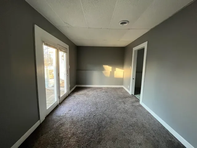 a view of an empty room with a chandelier fan