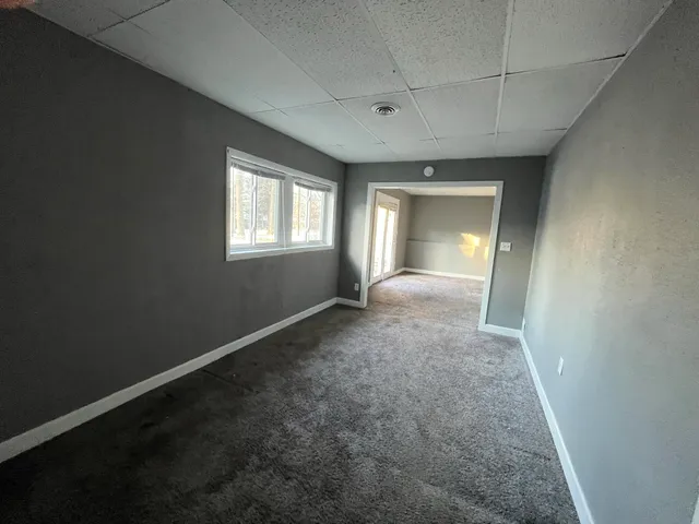 an empty room with a window and ceiling fan