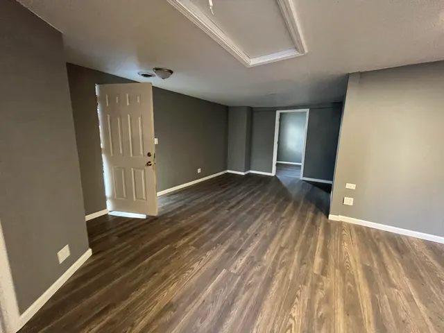 a view of an empty room with wooden floor