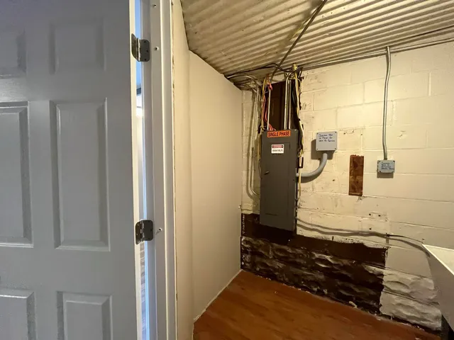 a view of a hallway with wooden floor and a cabinet