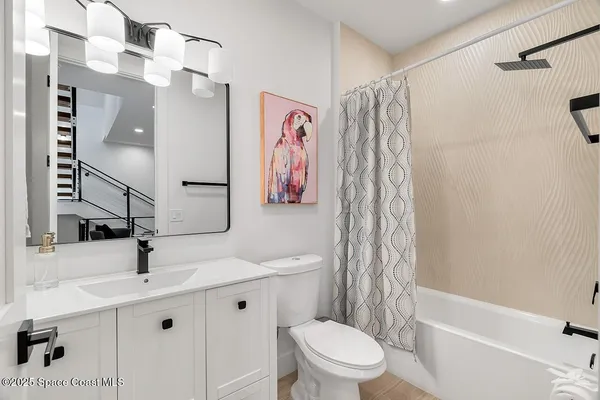 a bathroom with a sink a toilet and shower curtain