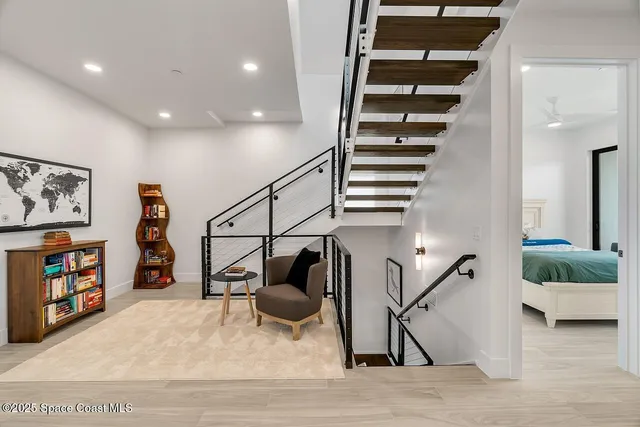 a view of a hallway with stairs and of a living room