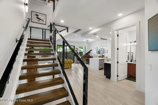 a view of staircase with white walls and wooden floor