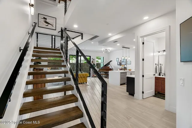 a view of staircase with white walls and wooden floor
