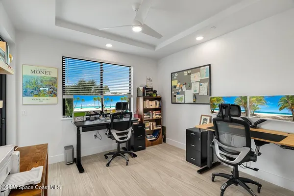 a view of a workspace with furniture and a window
