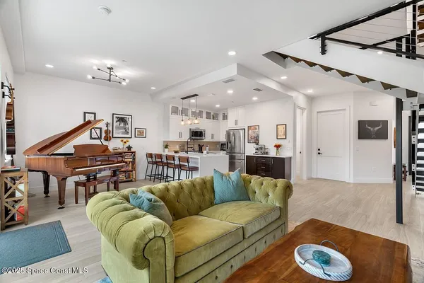a living room with furniture ceiling fan and a wooden floor