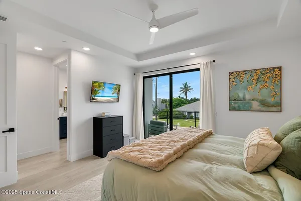 a bedroom with a balcony a bed and a television