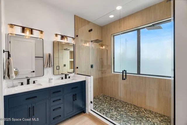 a bathroom with a double vanity sink a mirror and shower