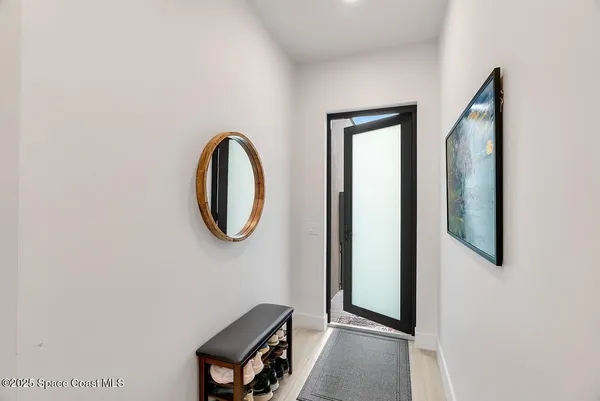 a view of a room with wooden floor and mirror