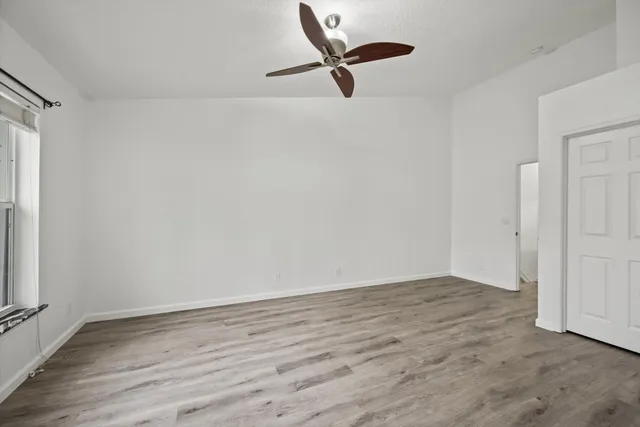 a view of a room with wooden floor and a window
