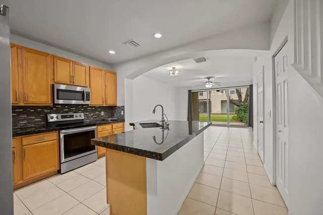 a kitchen with stainless steel appliances granite countertop a stove sink and cabinets