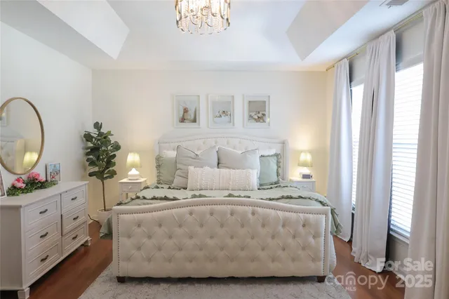 a bedroom with a bed a mirror and window