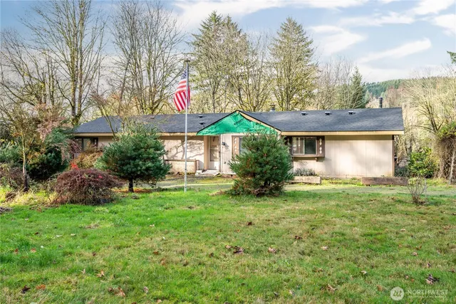 a yellow and red house sitting in the middle of a field
