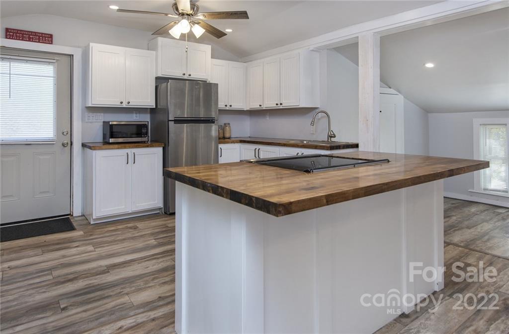 6910 Hickory Ridge Road Harrisburg, NC 28075 - Photo 18 of 21 a kitchen with a sink a counter top space cabinets and stainless steel appliances