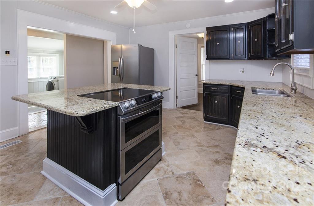 6910 Hickory Ridge Road Harrisburg, NC 28075 - Photo 7 of 21 a kitchen with granite countertop a sink and a stove top oven