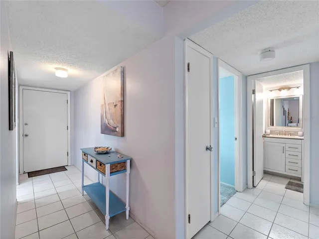 a view of a hallway to rooms and kitchen