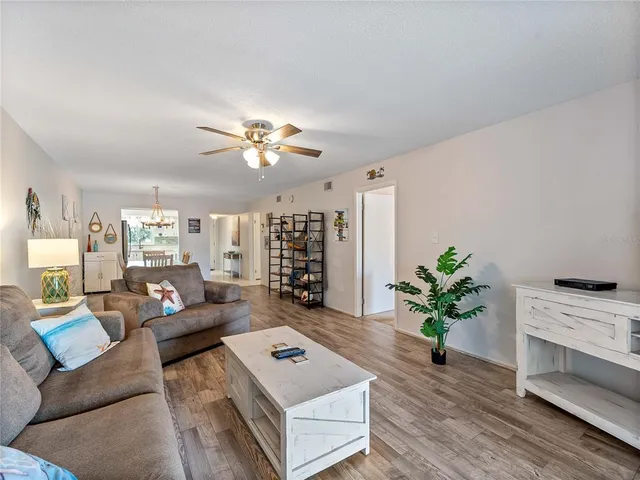 a living room with furniture flowerpot and a chandelier