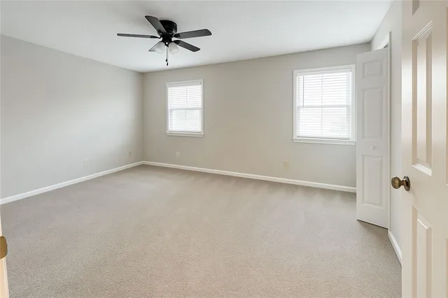an empty room with a window and a ceiling fan