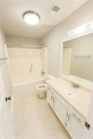 a bathroom with a granite countertop sink a toilet and bathtub