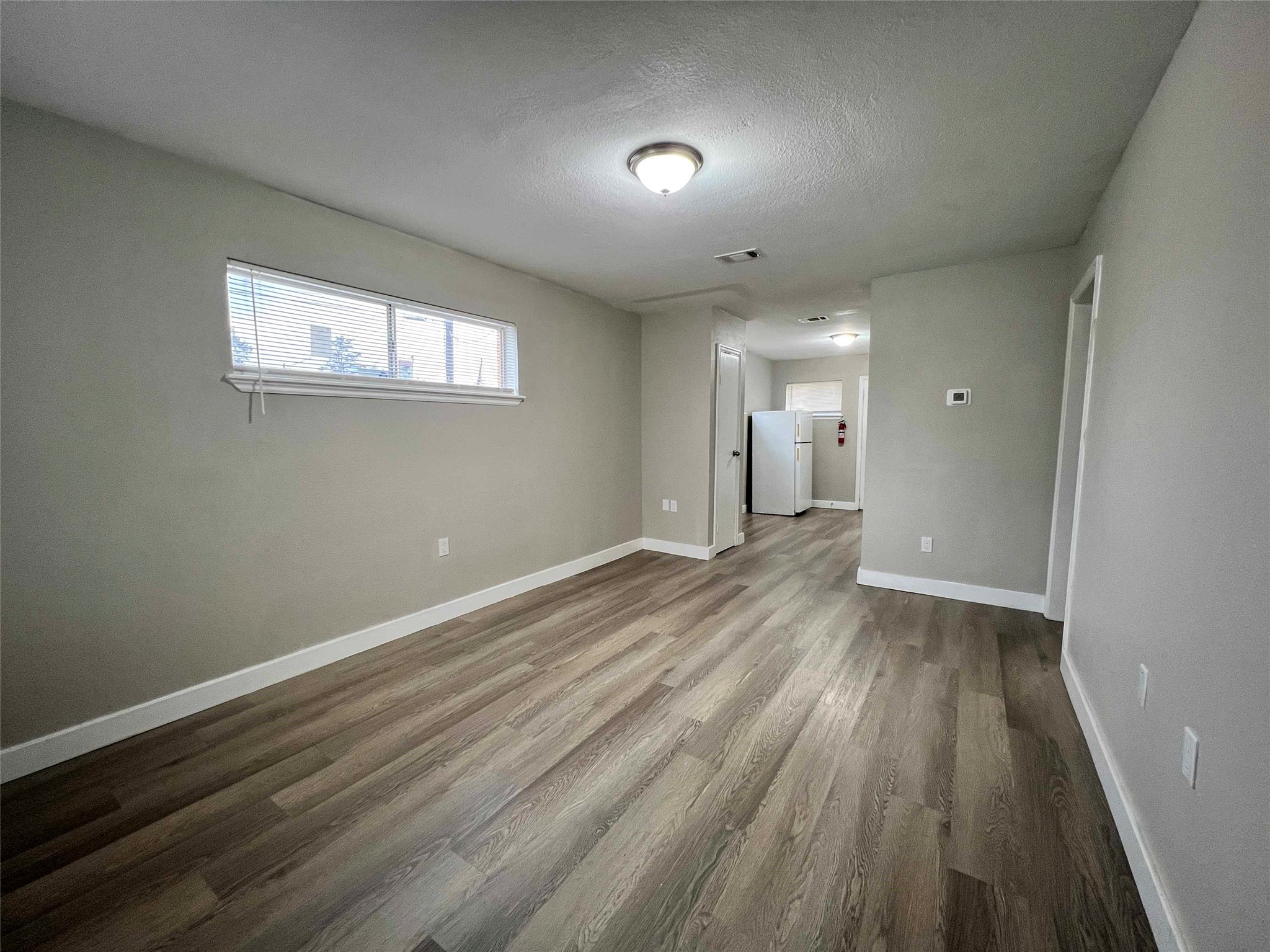 7814 Glass Street Houston, TX 77016 - Photo 3 of 7 wooden floor in an empty room with a window