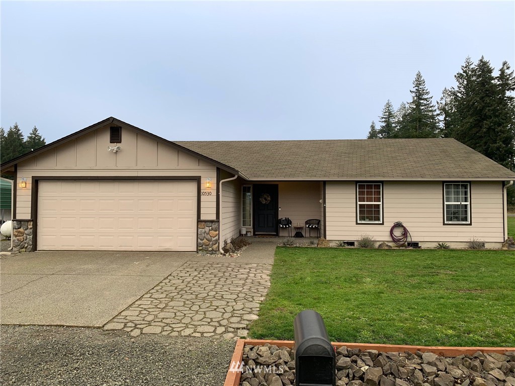10530 School Land Road Southwest Rochester, WA 98579 - Photo 1 of 27 a front view of a house with a yard and garage