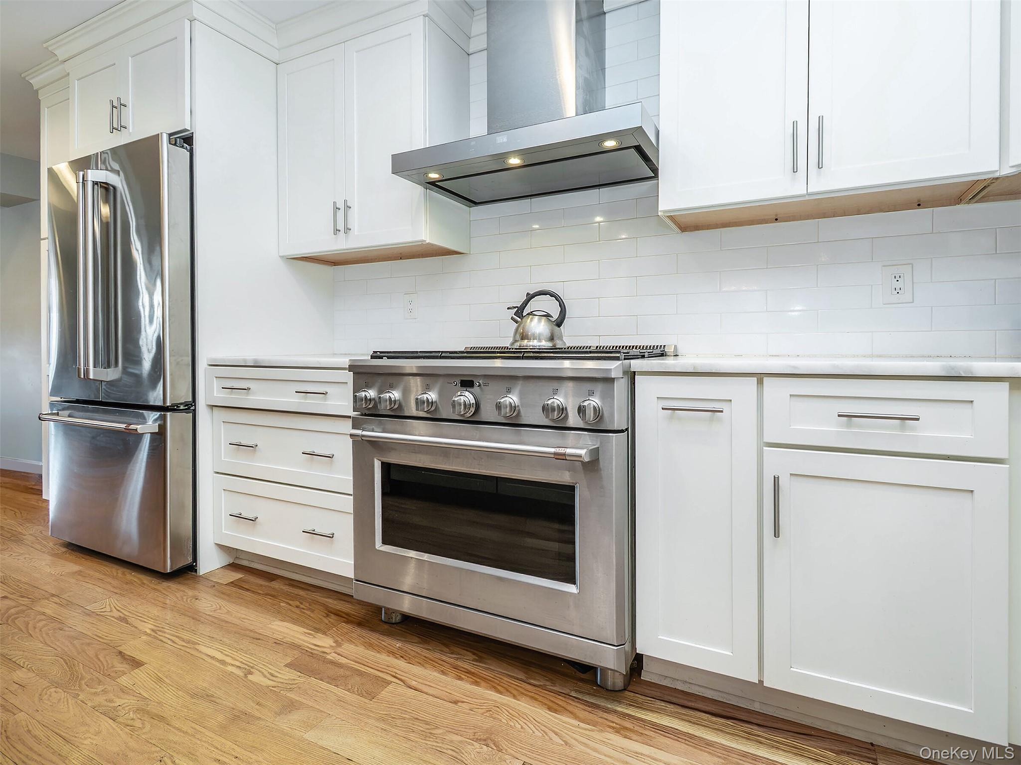 17 Winans Place Locust Valley, NY 11560 - Photo 12 of 34 a kitchen with stainless steel appliances white cabinets and a stove