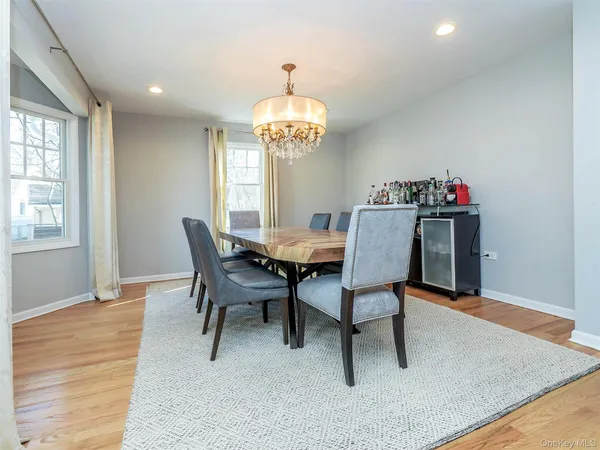 a dining room with furniture a chandelier and wooden floor