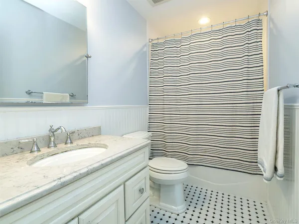 a bathroom with a granite countertop toilet and sink