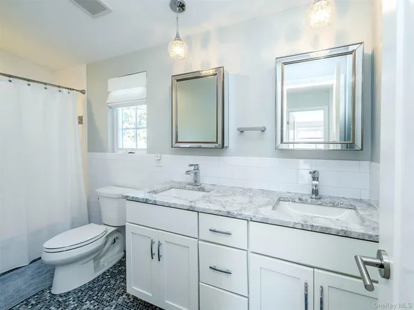 a bathroom with a granite countertop toilet sink and mirror