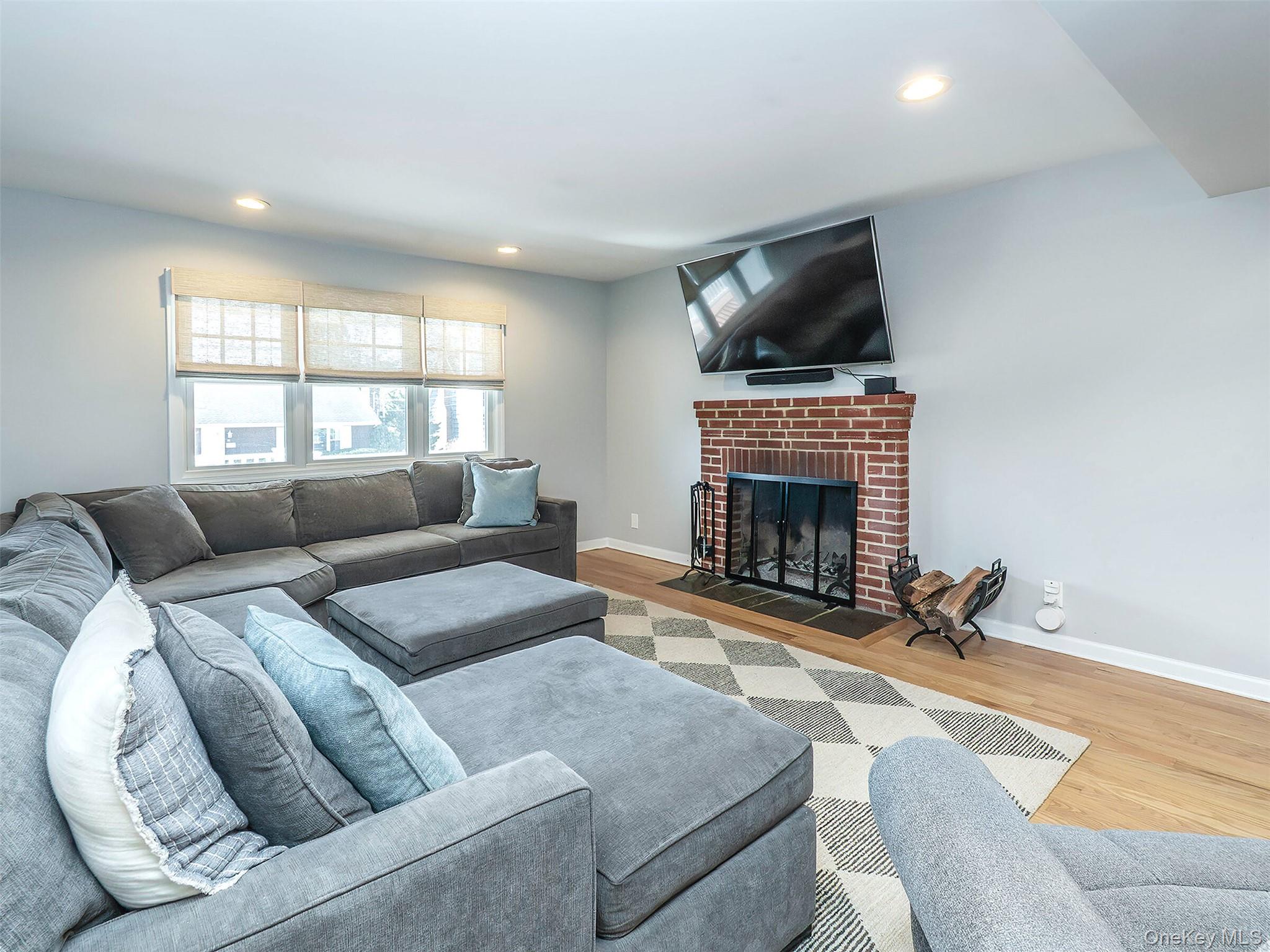 17 Winans Place Locust Valley, NY 11560 - Photo 6 of 34 a living room with furniture a flat screen tv and a fireplace