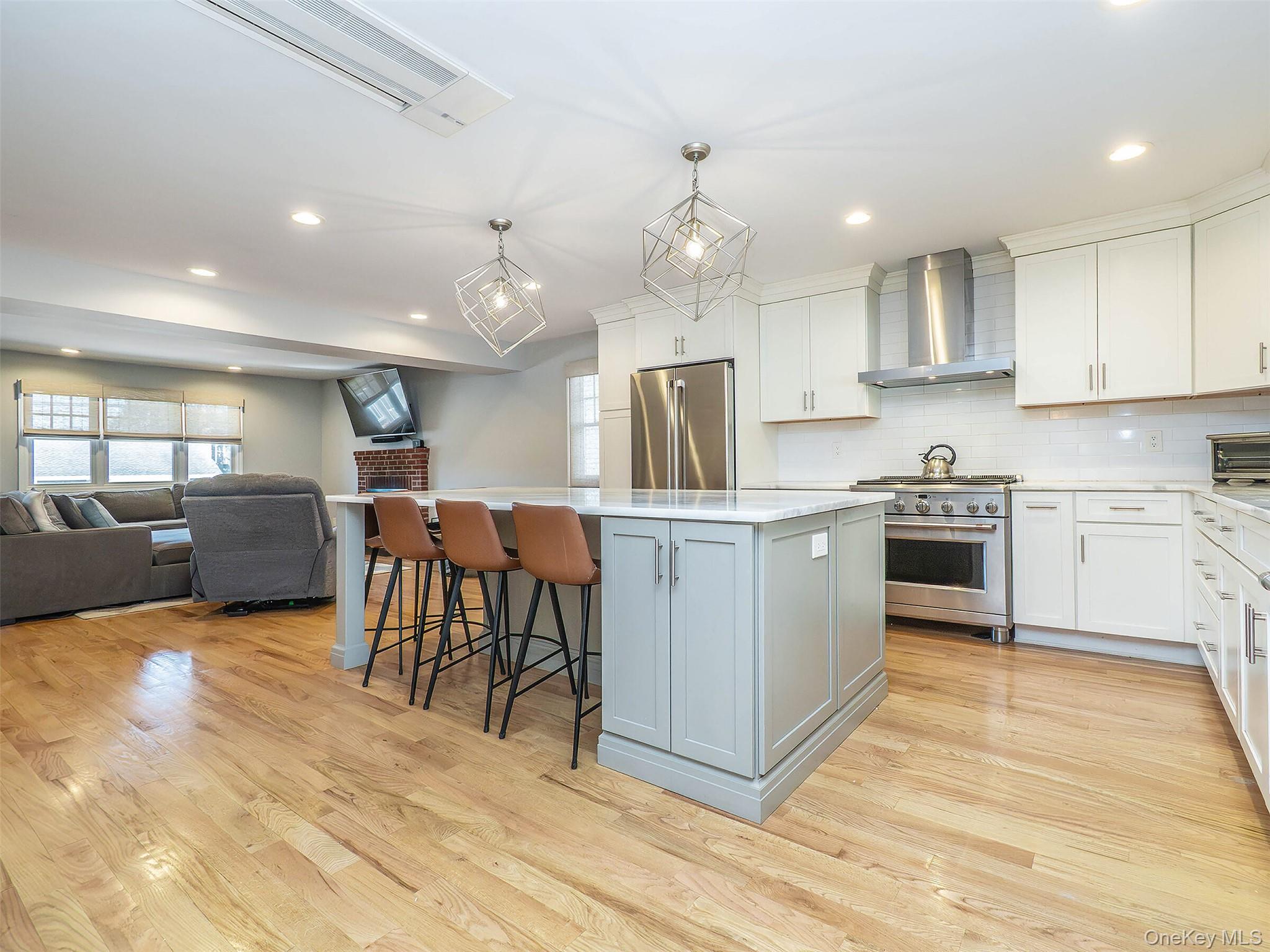 17 Winans Place Locust Valley, NY 11560 - Photo 10 of 34 a kitchen with kitchen island granite countertop wooden floors stainless steel appliances and white cabinets