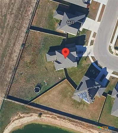 an aerial view of a house with a backyard