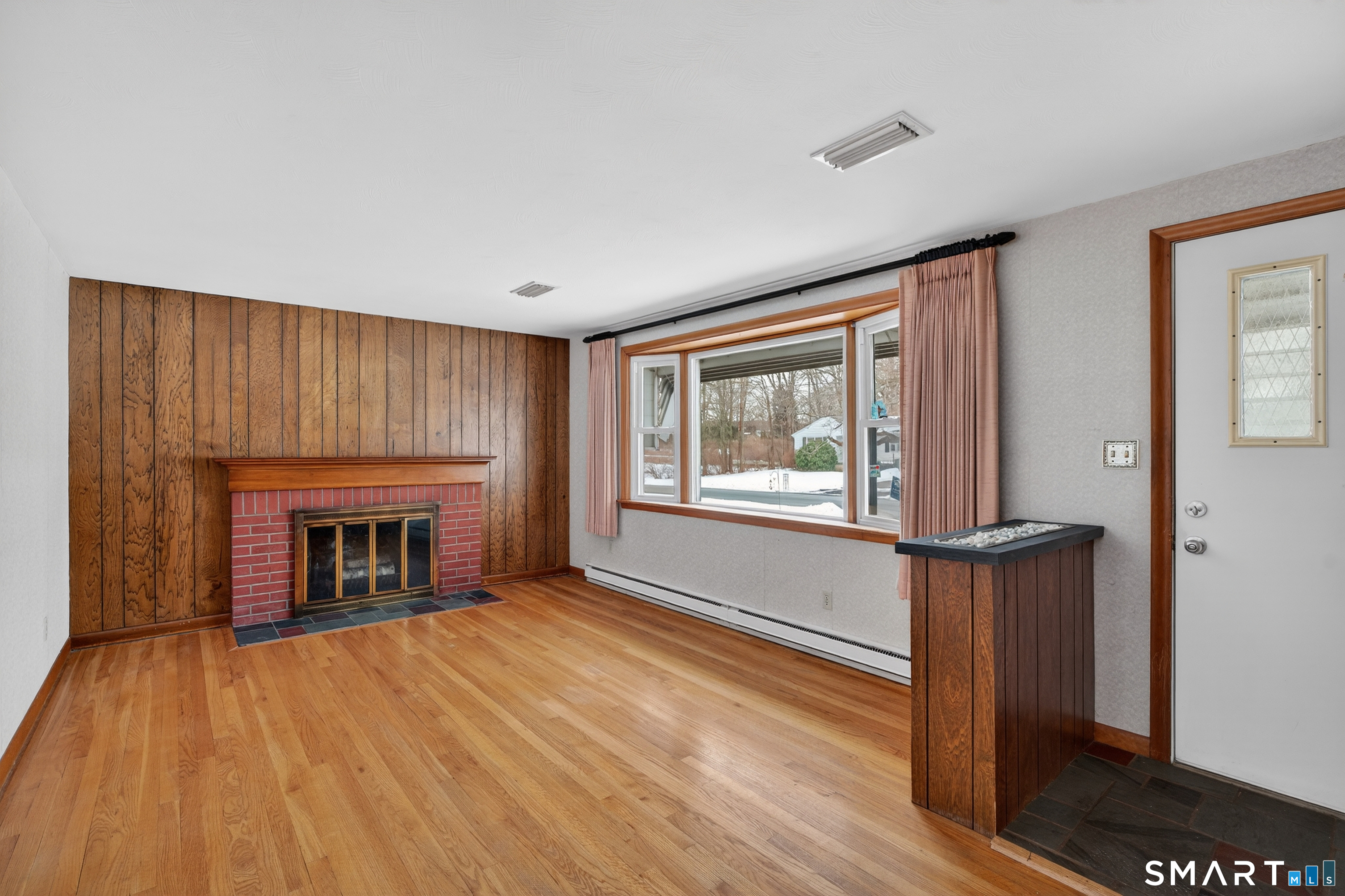 40 Quincy Lane Newington, CT 06111 - Photo 3 of 25 a view of an empty room with wooden floor fireplace and a window