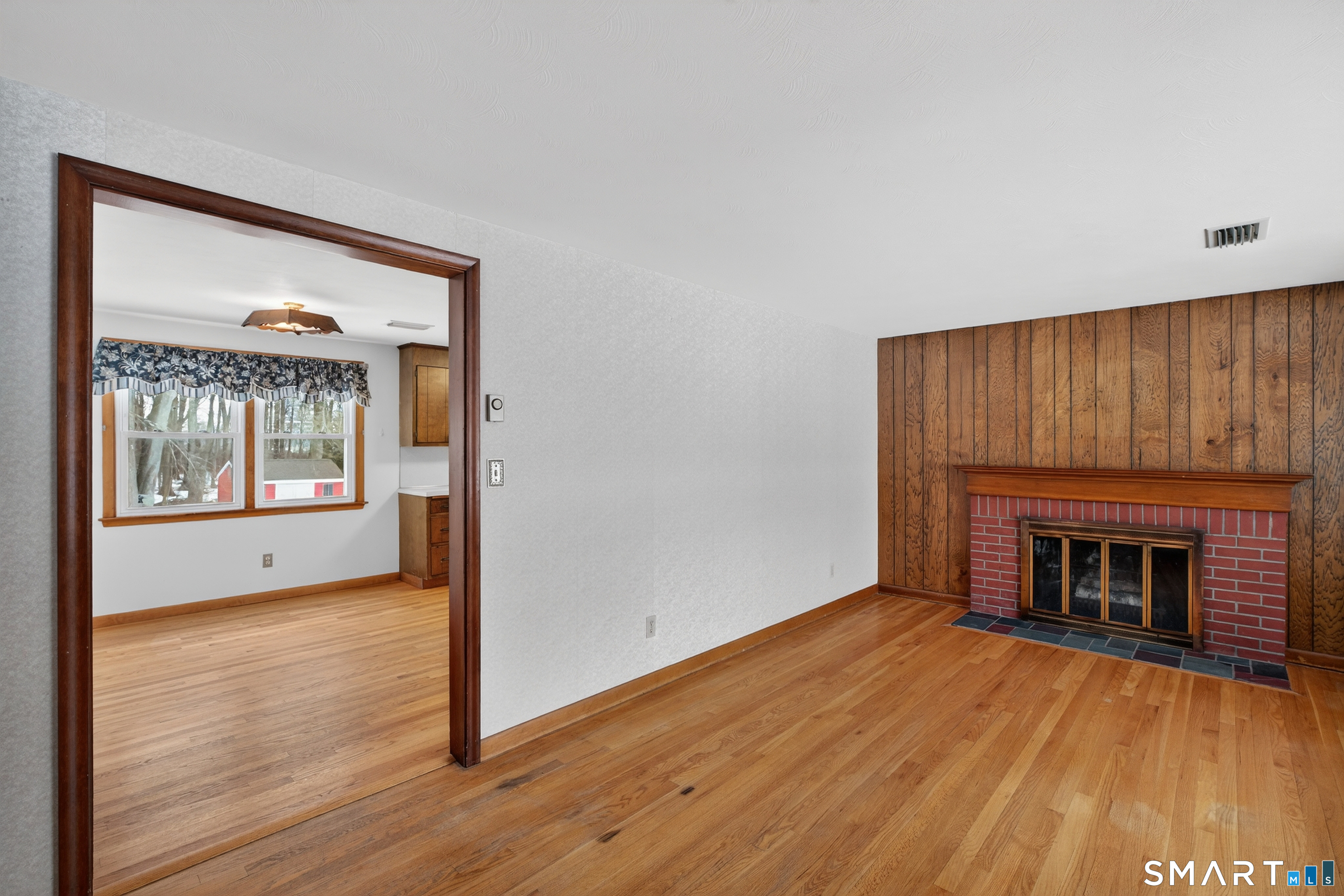40 Quincy Lane Newington, CT 06111 - Photo 5 of 25 a view of an empty room with wooden floor fireplace and a window