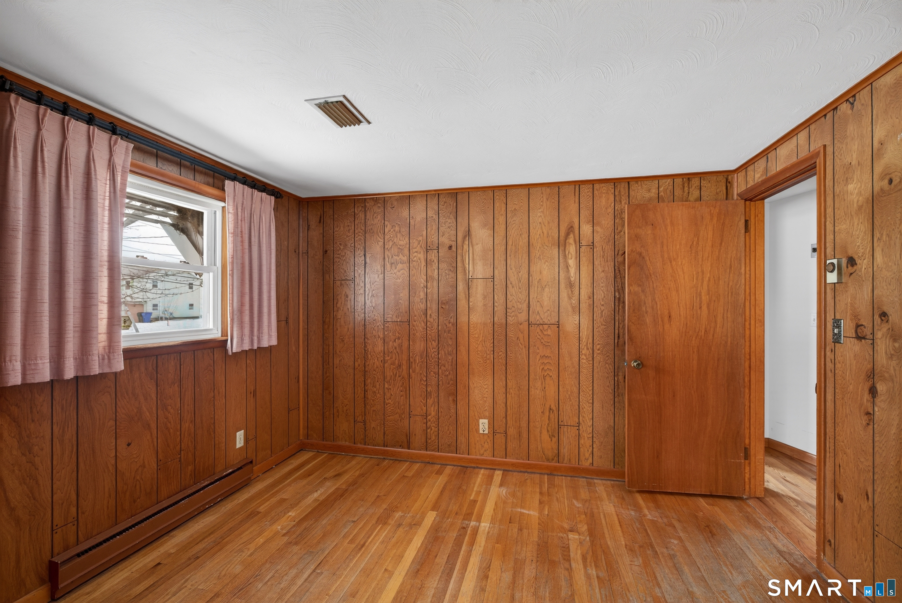 40 Quincy Lane Newington, CT 06111 - Photo 10 of 25 an empty room with wooden floor and windows with curtains
