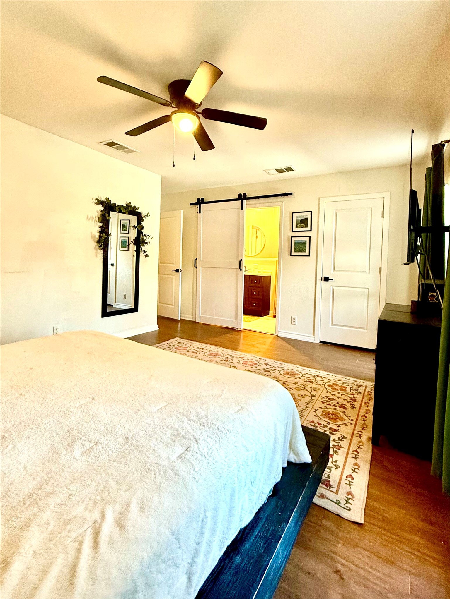 9507 Sherbrooke Street Austin, TX 78729 - Photo 12 of 29 Large primary bedroom featuring a barn door, en-suite.